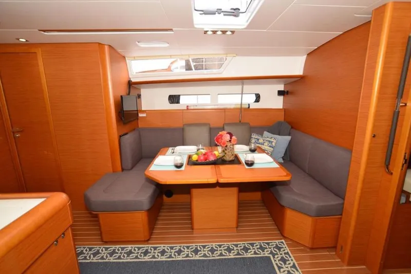 Leah Yacht Photos Pics 2014 Jeanneau Sun Odyssey 469 interior with cozy dining area and elegant wood finish.