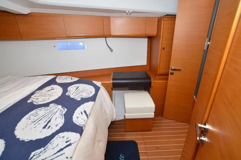 Leah Yacht Photos Pics 2014 Jeanneau Sun Odyssey 469 cabin with wooden interior and nautical-themed bedding.