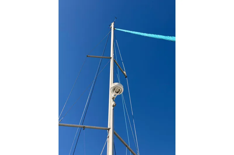 Leah Yacht Photos Pics Mast of 2014 Jeanneau Sun Odyssey 469 sailboat against clear blue sky.
