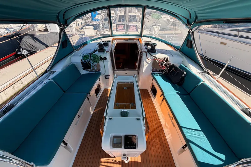 Leah Yacht Photos Pics 2014 Jeanneau Sun Odyssey 469 yacht cockpit with teal seating and wooden flooring.