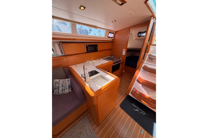Leah Yacht Photos Pics Interior of 2014 Jeanneau Sun Odyssey 469 sailboat with kitchen and seating area.