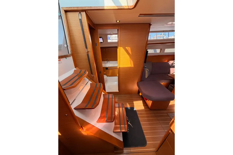 Leah Yacht Photos Pics Interior of 2014 Jeanneau Sun Odyssey 469 sailboat with wooden flooring and seating area.