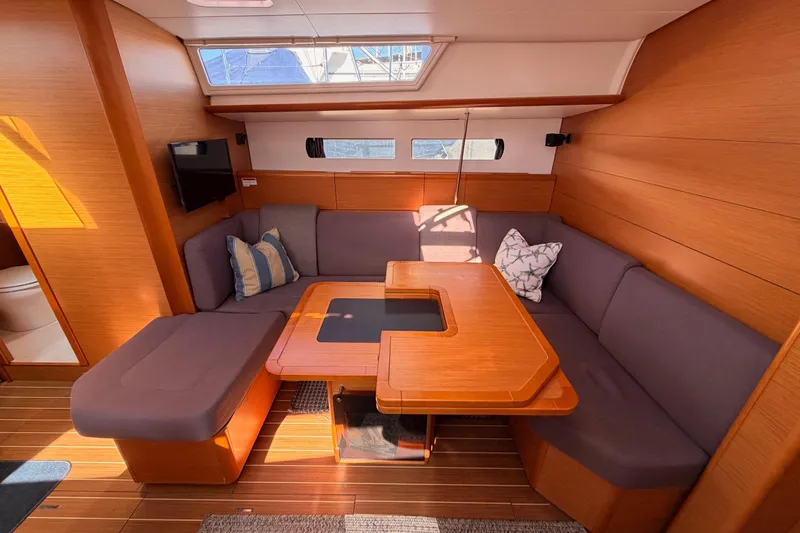 Leah Yacht Photos Pics 2014 Jeanneau Sun Odyssey 469 interior with cozy seating and wooden table.