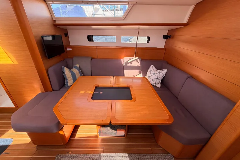 Leah Yacht Photos Pics Interior of 2014 Jeanneau Sun Odyssey 469 yacht with cozy seating and wooden table.