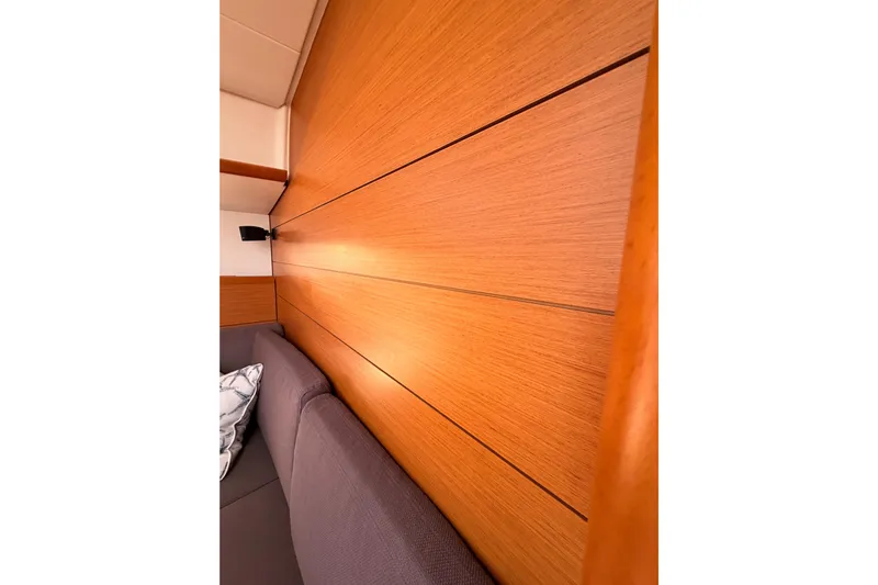 Leah Yacht Photos Pics Interior of 2014 Jeanneau Sun Odyssey 469, featuring wooden paneling and a gray sofa.