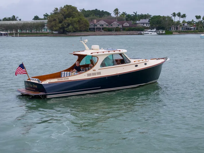 She's The One Yacht Photos Pics 2019 Hinckley Picnic Boat 34 cruising on calm waters, featuring classic design and American flag.