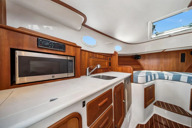 She's The One Yacht Photos Pics 2019 Hinckley Picnic Boat 34 interior with kitchenette, microwave, sink, and seating area.
