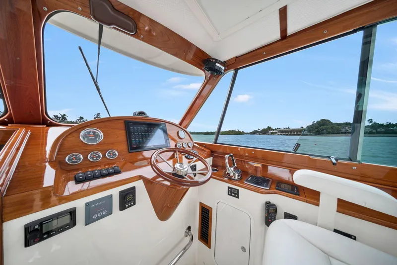 She's The One Yacht Photos Pics Helm of 2019 Hinckley Picnic Boat 34 with wooden dashboard and scenic water view.