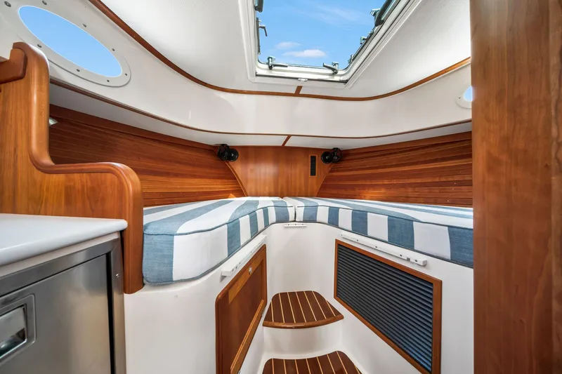 She's The One Yacht Photos Pics 2019 Hinckley Picnic Boat 34 interior with wood accents and striped cushions.