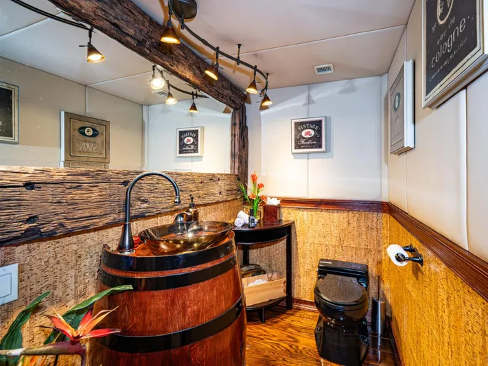 Le Montrachet Yacht Photos Pics Rustic bathroom on 1986 Broward Flybridge yacht with barrel sink and wood accents.