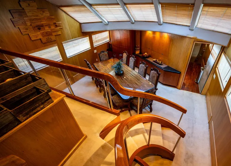 Le Montrachet Yacht Photos Pics Luxurious 1986 Broward Flybridge yacht interior with elegant dining area and wooden staircase.