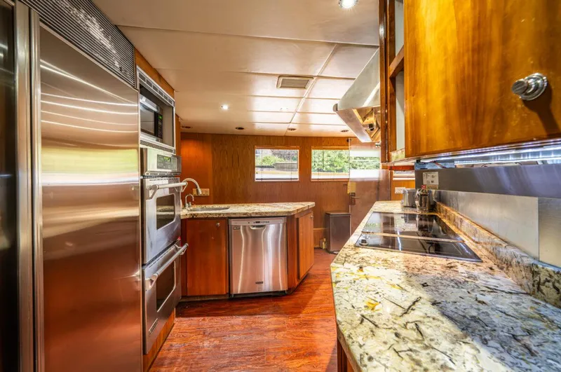 Le Montrachet Yacht Photos Pics Luxurious 1986 Broward Flybridge yacht kitchen with modern appliances and granite countertops.