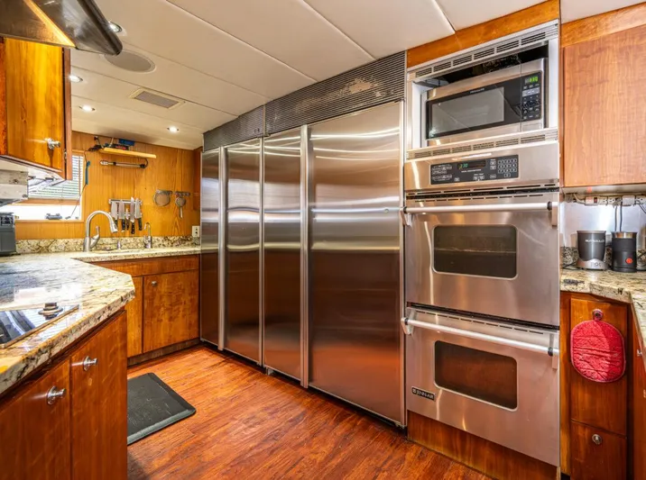 Le Montrachet Yacht Photos Pics Luxurious 1986 Broward Flybridge yacht kitchen with stainless steel appliances and wood cabinetry.