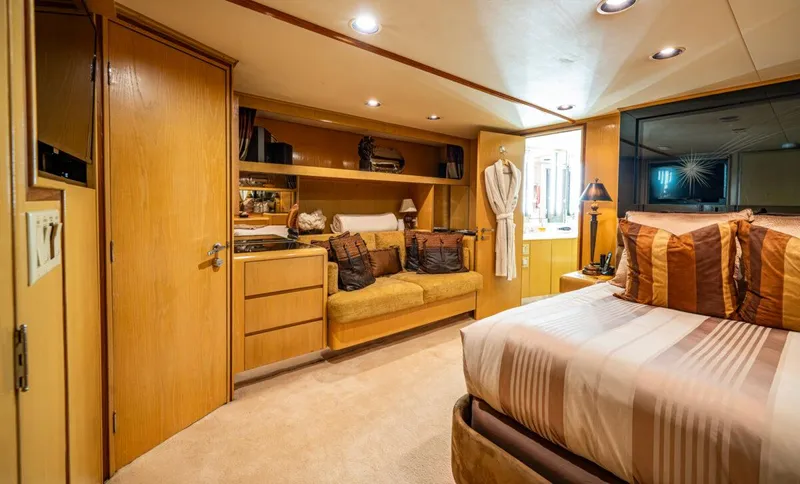 Le Montrachet Yacht Photos Pics Luxurious 1986 Broward Flybridge yacht bedroom with cozy seating and elegant decor.