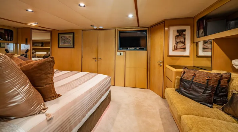 Le Montrachet Yacht Photos Pics Luxurious 1986 Broward Flybridge yacht bedroom with elegant decor and cozy seating area.