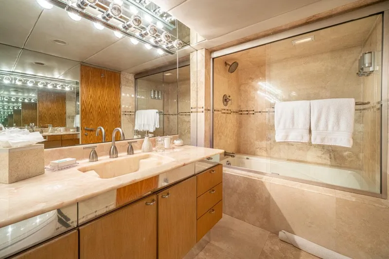 Le Montrachet Yacht Photos Pics Luxurious bathroom on 1986 Broward Flybridge yacht with marble sink and glass-enclosed shower.