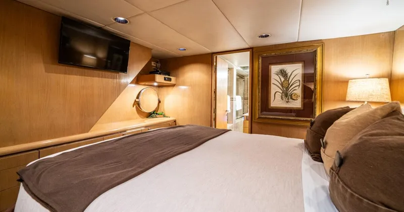 Le Montrachet Yacht Photos Pics Luxurious 1986 Broward Flybridge yacht bedroom with elegant decor and modern amenities.
