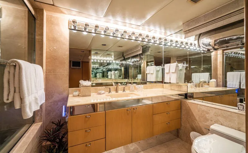 Le Montrachet Yacht Photos Pics Luxurious bathroom on 1986 Broward Flybridge yacht with mirrored walls and elegant lighting.