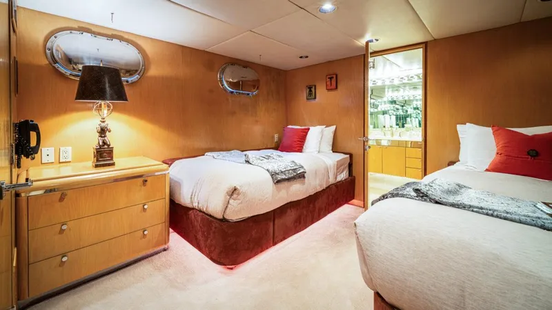 Le Montrachet Yacht Photos Pics Luxurious 1986 Broward Flybridge yacht bedroom with twin beds and elegant decor.