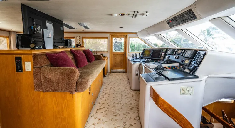 Le Montrachet Yacht Photos Pics 1986 Broward Flybridge yacht interior with helm, plush seating, and panoramic windows.