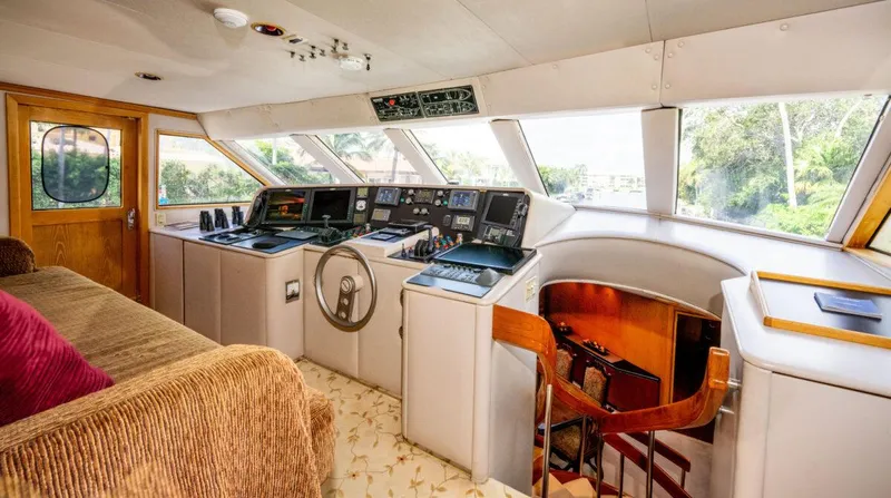 Le Montrachet Yacht Photos Pics 1986 Broward Flybridge yacht interior with helm, controls, and seating area.