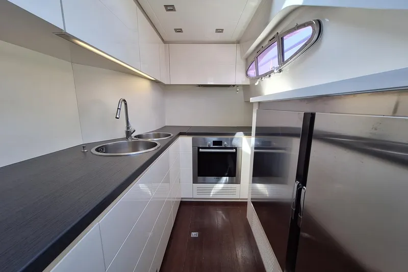 Mylo Yacht Photos Pics Modern kitchen interior on 2014 Pershing 74 yacht with sleek design and stainless steel appliances.