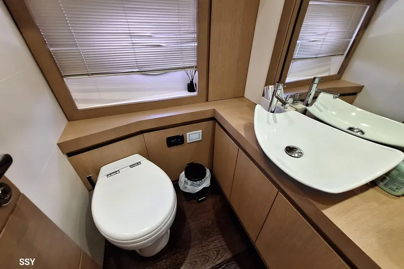 Mylo Yacht Photos Pics Luxurious bathroom in 2014 Pershing 74 yacht with modern fixtures and wooden accents.