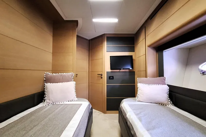 Mylo Yacht Photos Pics Luxurious twin cabin interior of 2014 Pershing 74 yacht with modern decor and TV.
