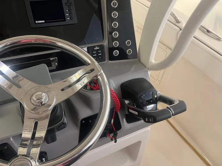  Yacht Photos Pics 2021 Robalo R272 Center Console helm with steering wheel and control panel.