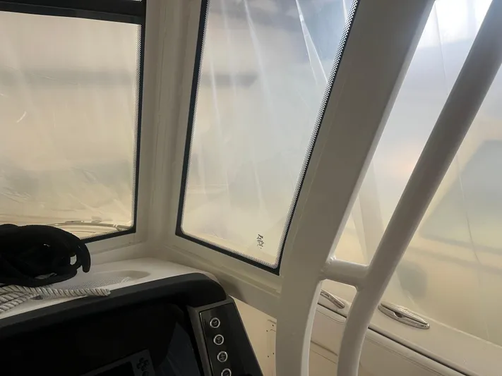  Yacht Photos Pics 2021 Robalo R272 Center Console interior with protective covering and control panel.