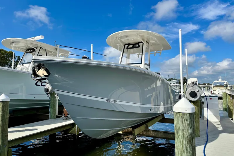  Yacht Photos Pics 2025 Regulator 23 boat docked at marina under clear blue sky.
