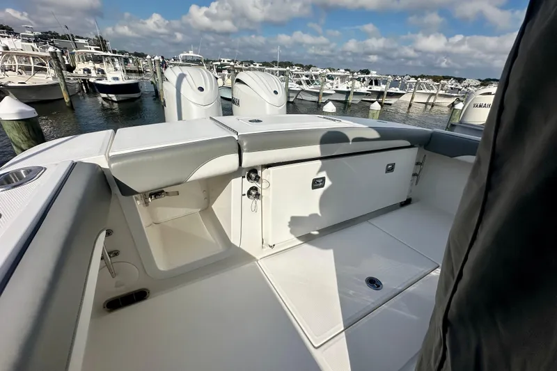  Yacht Photos Pics 2025 Regulator 23 boat interior with seating, docked at marina under cloudy sky.