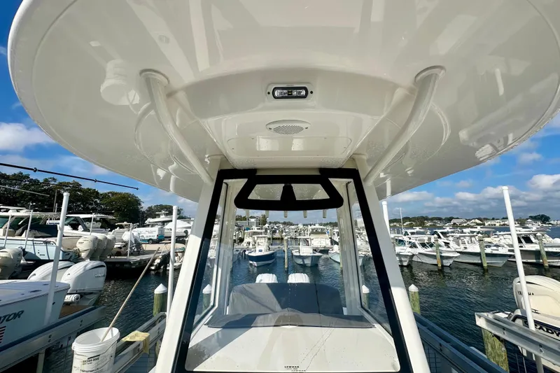  Yacht Photos Pics 2025 Regulator 23 boat docked at marina, surrounded by other vessels under a clear sky.