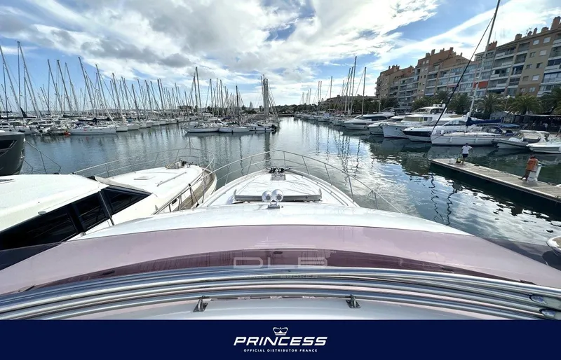  Yacht Photos Pics Luxury Princess 64 yacht docked in marina, 2012 model, surrounded by sailboats under cloudy sky.