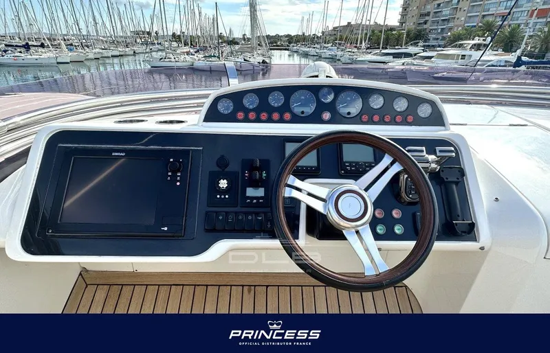  Yacht Photos Pics Steering console of a 2012 Princess 64 yacht, featuring modern navigation controls.
