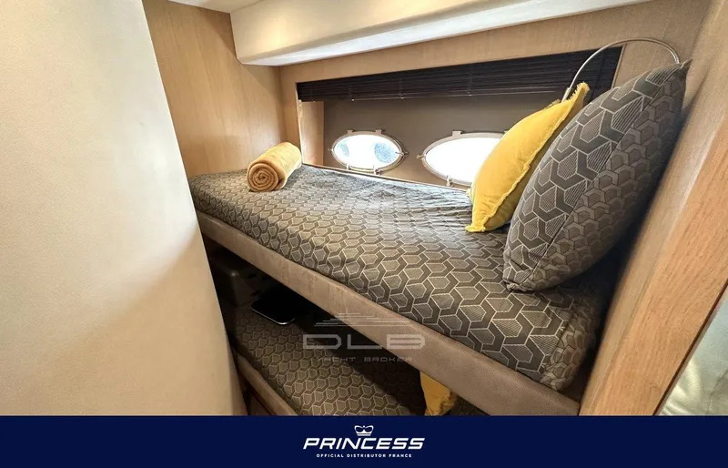  Yacht Photos Pics Bunk beds in 2012 Princess 64 yacht cabin with porthole windows and cozy bedding.