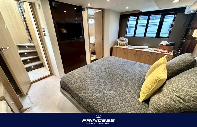  Yacht Photos Pics Luxurious bedroom interior of 2012 Princess 64 yacht with modern furnishings and large windows.