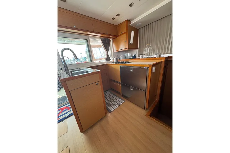 Audacity Yacht Photos Pics Modern kitchen interior of 2013 Lagoon 450 yacht with wood cabinetry and stainless steel appliances.