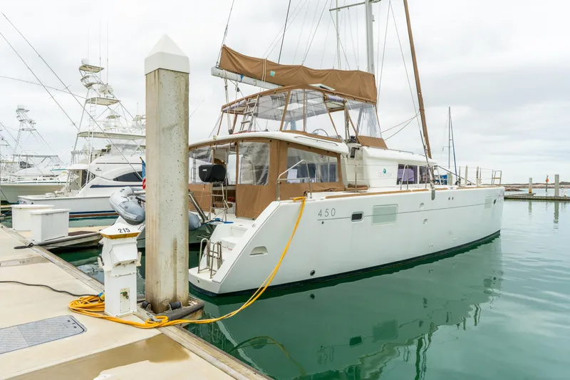 Audacity Yacht Photos Pics 2013 Lagoon 450 catamaran docked at marina, featuring sleek design and spacious deck.