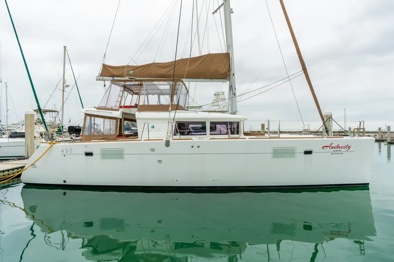 Audacity Yacht Photos Pics 2013 Lagoon 450 catamaran docked in marina, featuring sleek design and spacious deck.