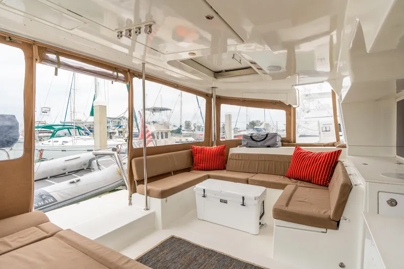 Audacity Yacht Photos Pics Spacious interior of 2013 Lagoon 450 catamaran with comfortable seating and red cushions.
