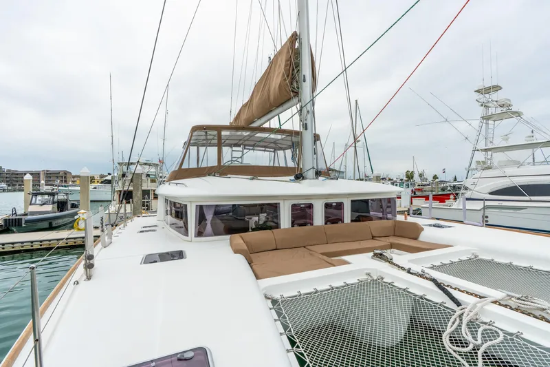 Audacity Yacht Photos Pics 2013 Lagoon 450 catamaran docked at marina, featuring spacious deck and netted lounging area.