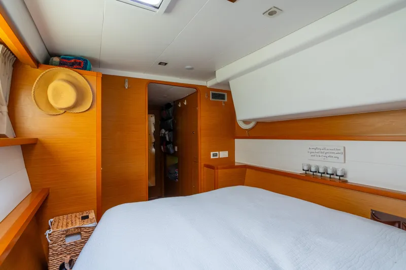 Audacity Yacht Photos Pics Interior of 2013 Lagoon 450 yacht cabin with cozy bed and wooden accents.