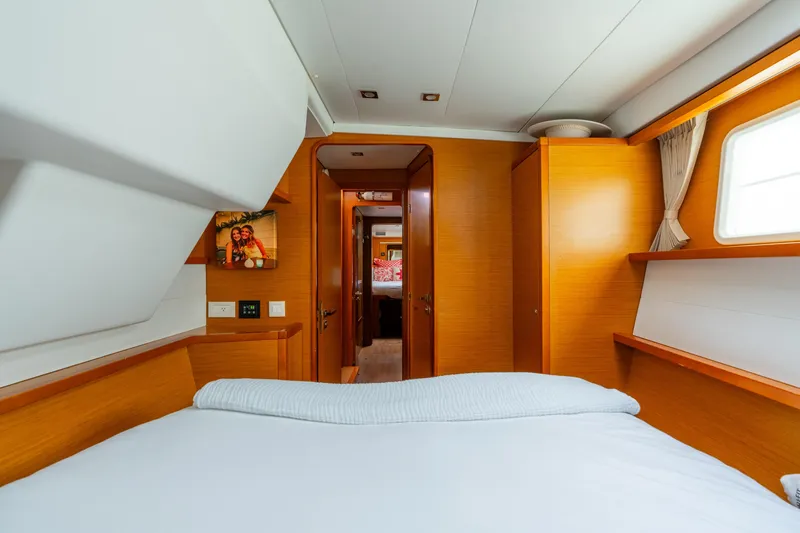 Audacity Yacht Photos Pics Interior of 2013 Lagoon 450 yacht cabin with cozy bed and wooden furnishings.