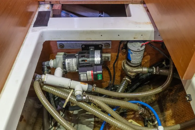 Audacity Yacht Photos Pics Engine compartment of a 2013 Lagoon 450 catamaran, showcasing pumps and hoses.