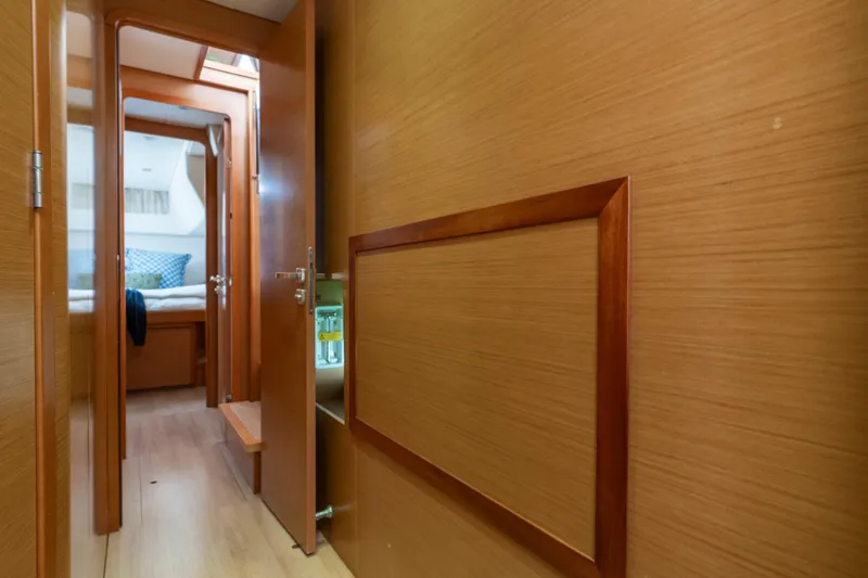 Audacity Yacht Photos Pics Interior hallway of 2013 Lagoon 450 yacht, featuring wooden paneling and cozy cabin view.