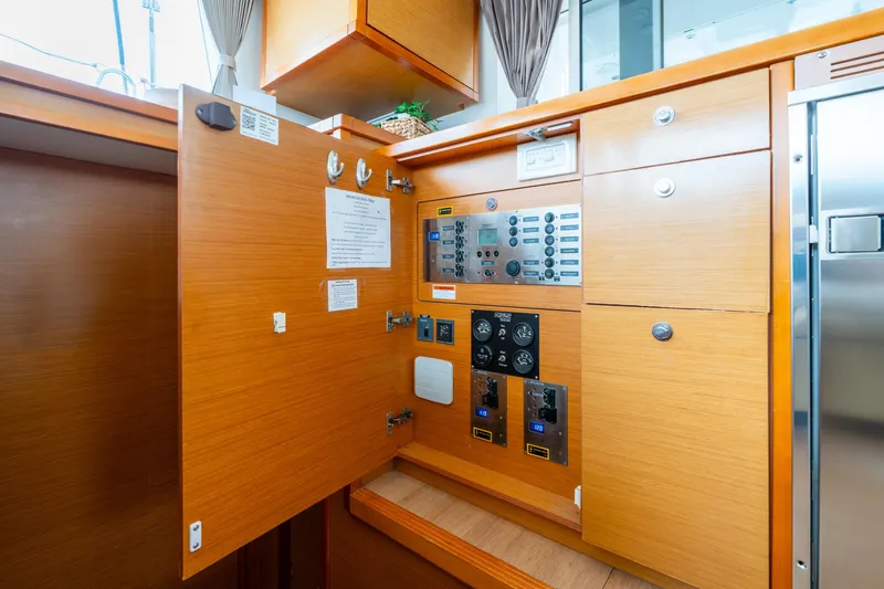 Audacity Yacht Photos Pics Electrical panel inside 2013 Lagoon 450 yacht with wooden cabinetry and control gauges.