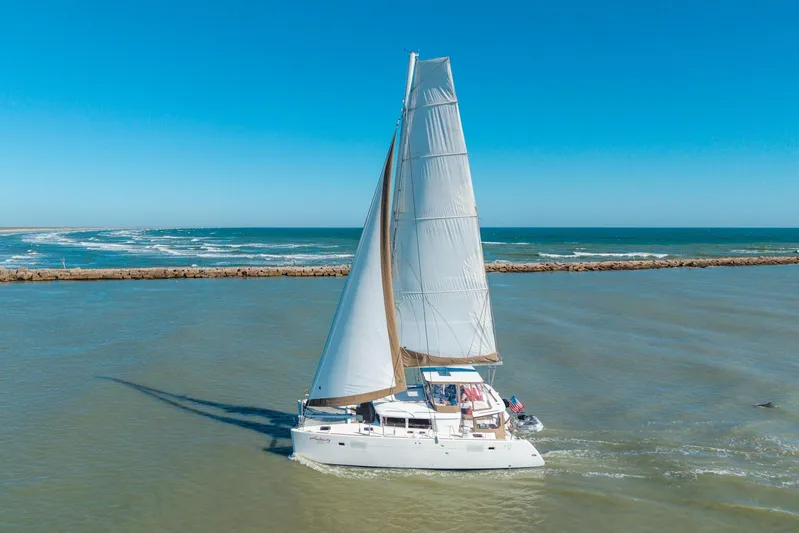 Audacity Yacht Photos Pics 2013 Lagoon 450 catamaran sailing on open sea under clear blue sky.