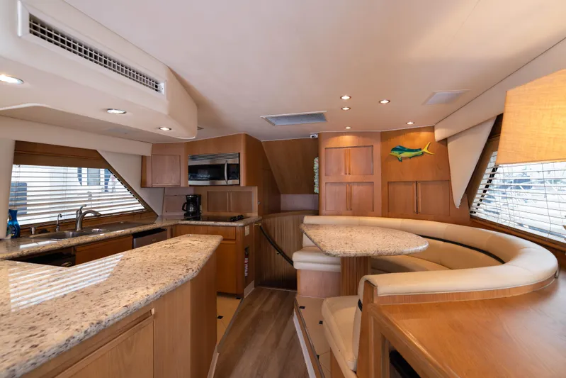 Premium Yacht Photos Pics Interior of 1996 Hatteras Convertible Sportfisher yacht with modern kitchen and dining area.