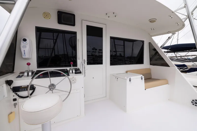 Premium Yacht Photos Pics 1996 Hatteras Convertible Sportfisher boat interior with steering wheel and seating area.